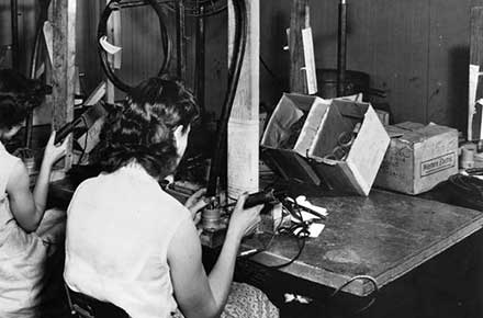 Employees at Clark Cable Corporation solder wire harnesses by hand, 1952