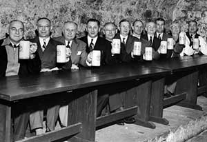 Group of brewery employees hoist a toast in rathskeller at Leisy Brewery