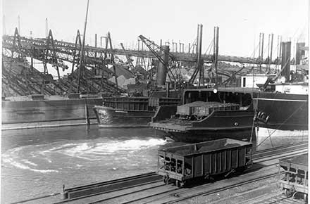 View of harbor with ships, rail cars, and Brownhoists