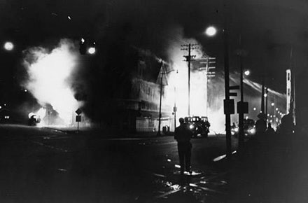 A pharmacy and a supermarket burn in fires set during the Hough riots of 1966