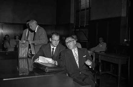 Sam Sheppard sits with his lawyers in the courtroom, 1954.