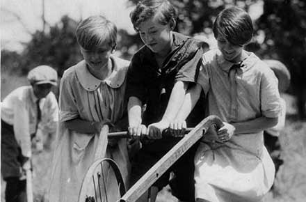 Three Cleveland Public School students work the plow together in the school garden, July, 1927.