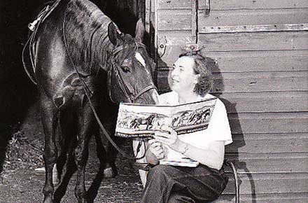 Ruth Douglas from the CCPL accounts department reads to a horse, 1958