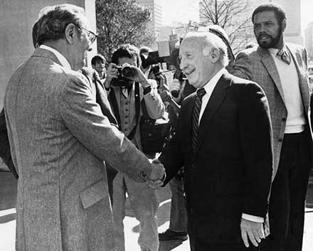 Joseph E. Cole (right) shakes hands with Herb Kamm, 1980