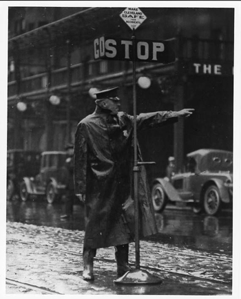 Cleveland Police patrolman Robert Kern directing traffic in the rain, c. 1920