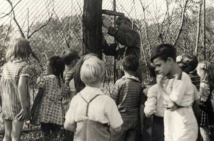 Young students observe as an adult installs a shelter for wildlife at a school in Cleveland, Ohio