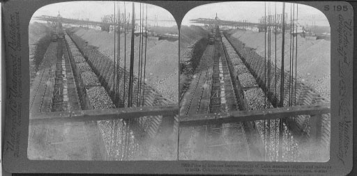 Piles of iron ore between docks of Lake steamers (right) and railways to mills, Conneaut, Ohio.